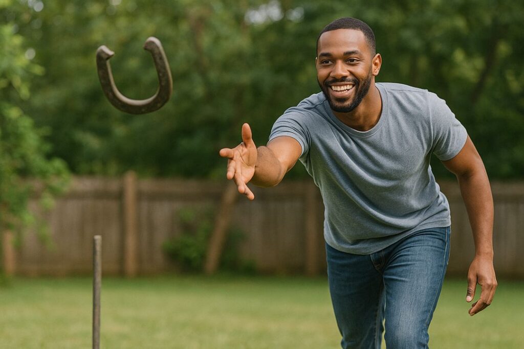 African American man focused on tossing a horseshoe toward the stake in a grassy backyard setting.
