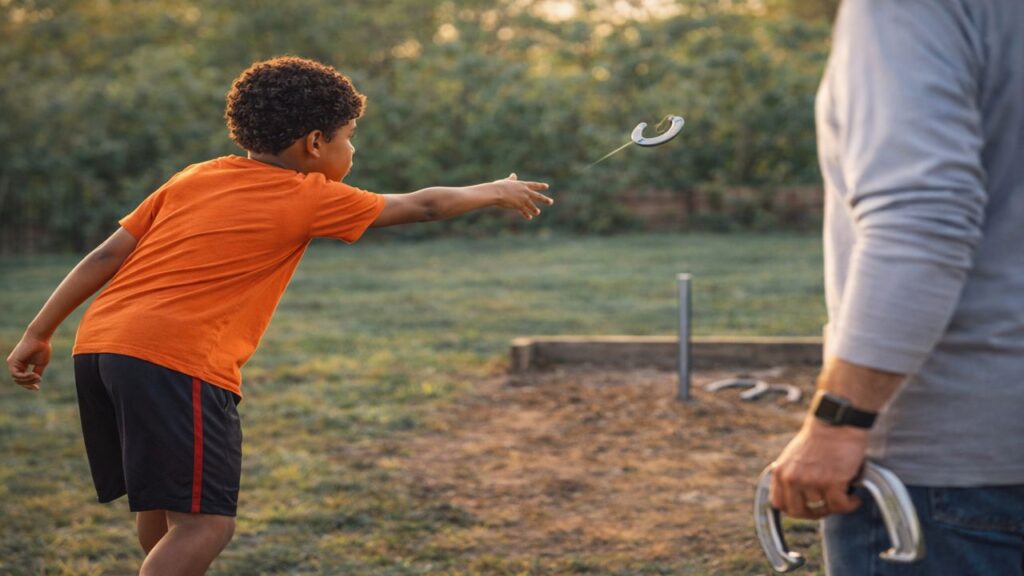 Young boy throwing a horseshoe toward the stake while learning the game in a family backyard setting